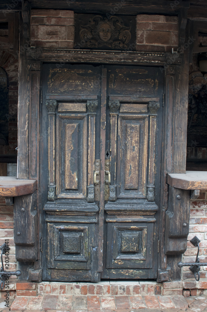Old wooden door close-up on a background of a wall Old wooden door close-up on a background of a wall