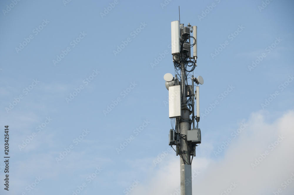 Cell tower closeup against a white sky.