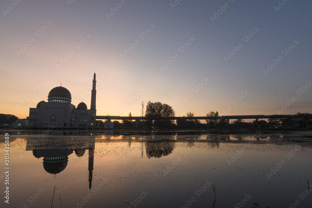 Closeup view of sunrise with reflection of mosque on water during blue hour and haze/blurry weather. Selective focus and crop fragment.