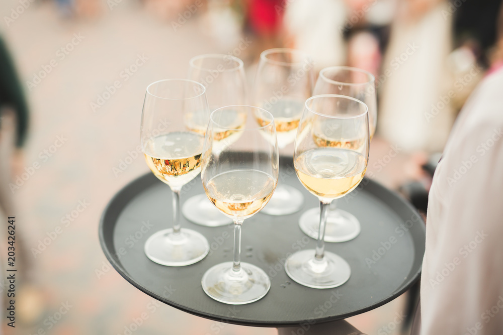Waiter serving glasses with champagne on a tray Waiter serving glasses with champagne on a tray