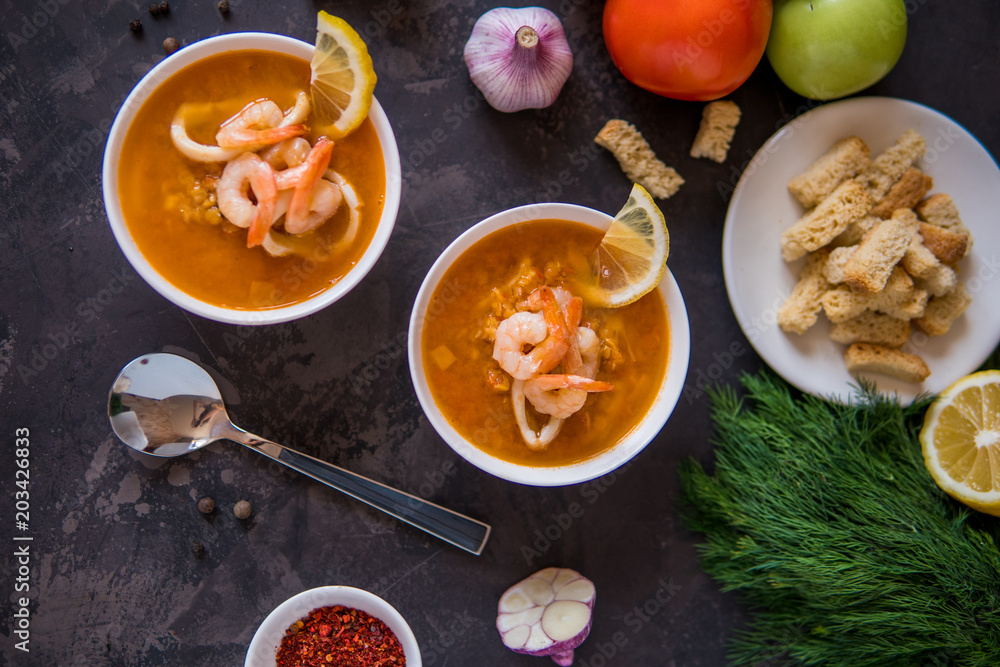 Lentil soup with seafood. Red soup with shrimps and squid top view Lentil soup with seafood. Red soup with shrimps and squid top view