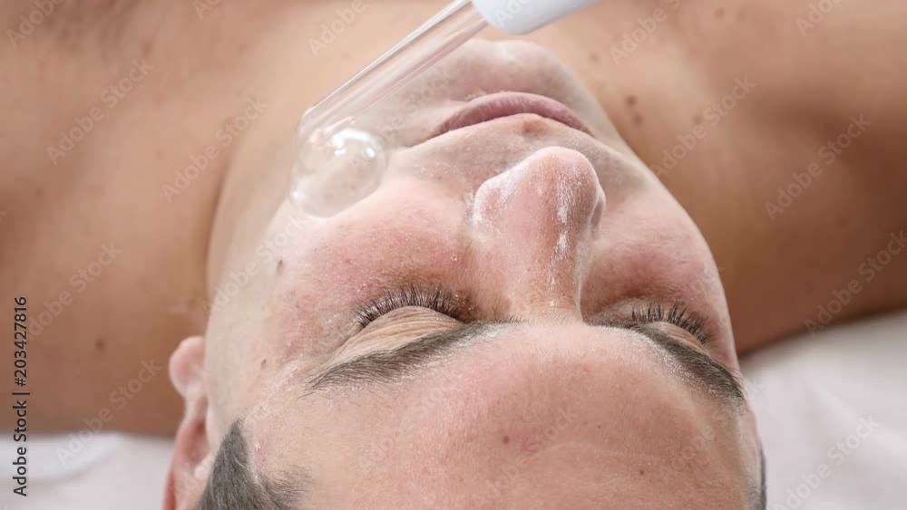 Darsonvalization. Man having darsonval therapy. Facial skin care in beauty saloon. electric darsonval massage procedure Darsonvalization. Man having darsonval therapy. Facial skin care in beauty saloon. electric darsonval massage procedure