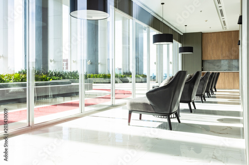 Row of chairs in executive office waiting room. background outdoor modern lobby big window and blue sky with clouds.