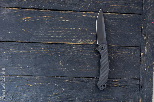 Switchblade knife. Black knife on a black background. photo