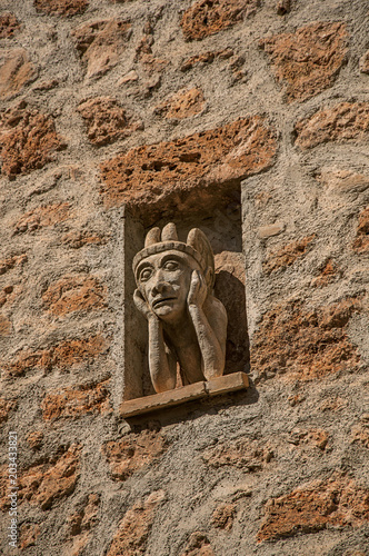 Close-up of stone wall with gargoyle in niche, at the gorgeous medieval hamlet of Les Arcs-sur-Argens, near Draguignan. Located in the Provence region, Var department, southeastern France