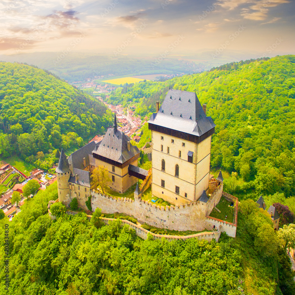 Aerial view to The Karlstejn castle. Royal palace founded King Charles IV. Amazing gothic monument in Czech Republic, Europe. Aerial view to The Karlstejn castle. Royal palace founded King Charles IV. Amazing gothic monument in Czech Republic, Europe.