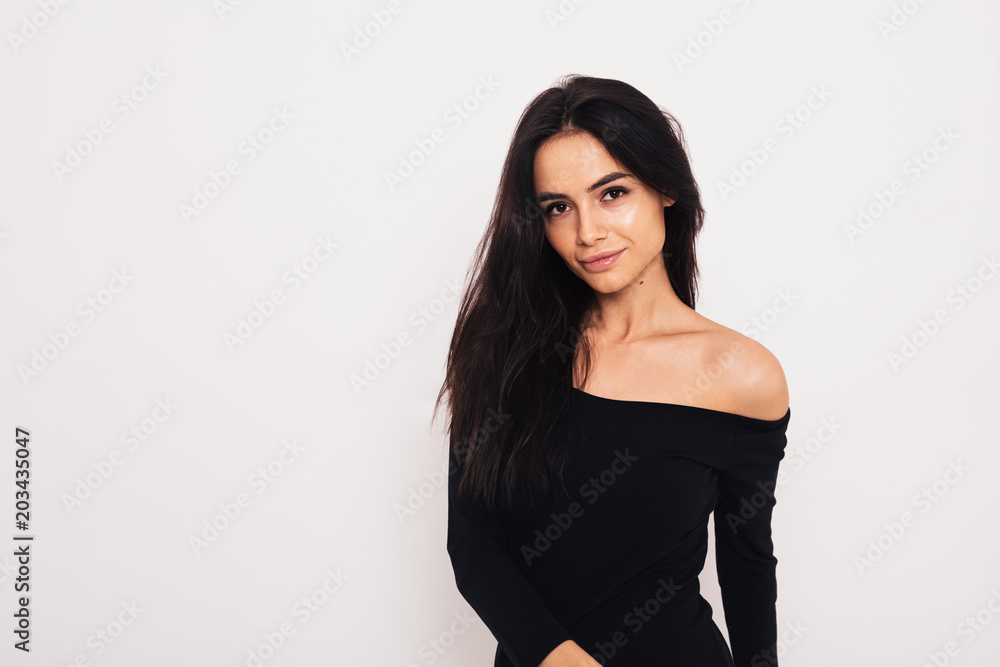 Woman in black dress standing in studio Woman in black dress standing in studio