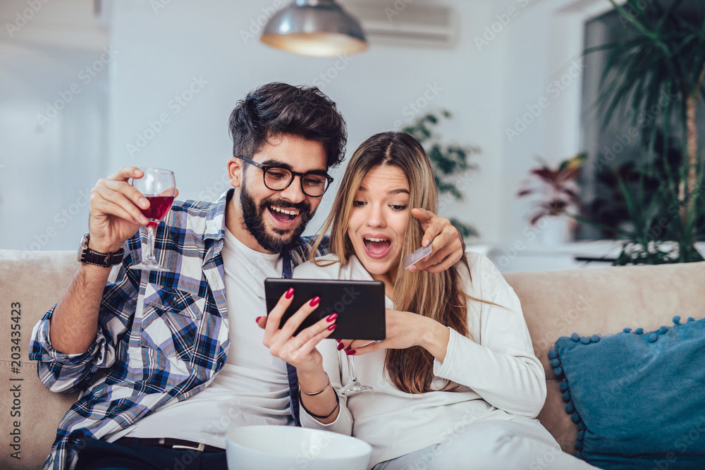 technology, online shopping and people concept - smiling happy couple couple with tablet pc computer and credit card at home