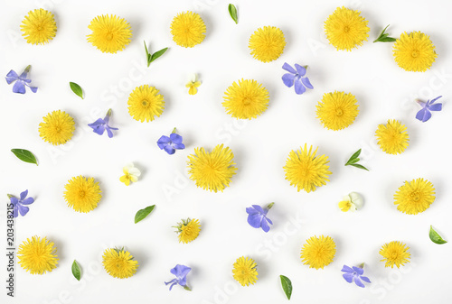 Fototapeta Naklejka Na Ścianę i Meble -  Floral pattern made of yellow dandelion, lilac flowers and leaves isolated on white background. Flat lay. Top view.