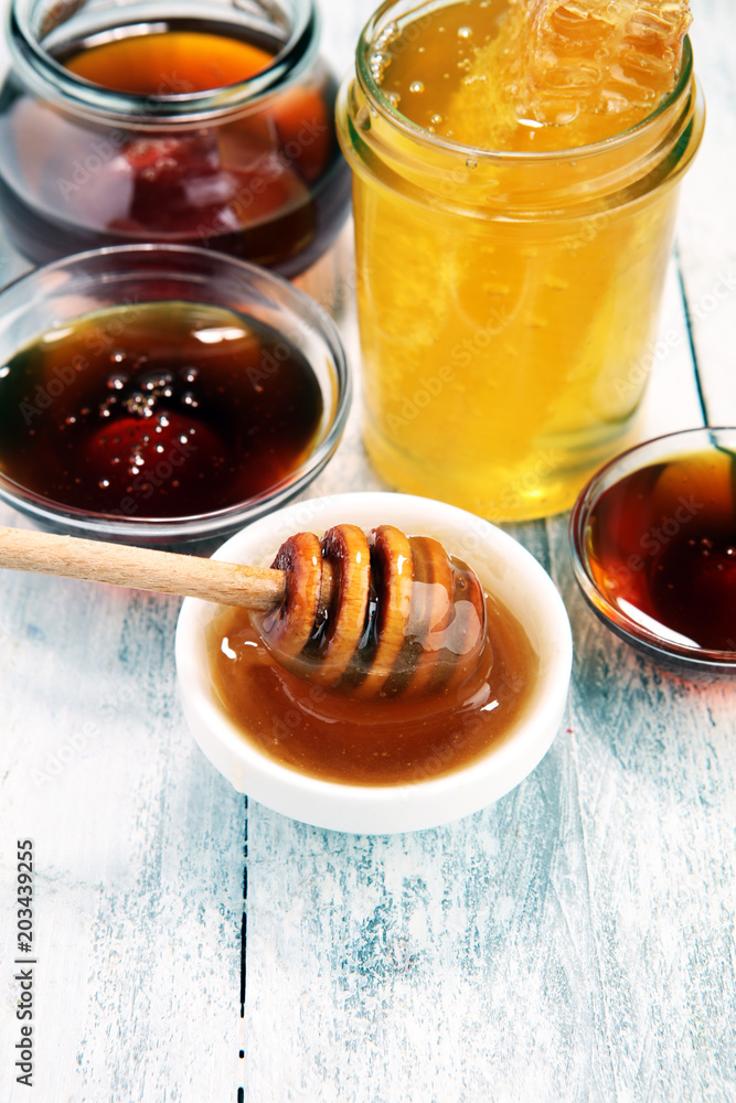 Pouring aromatic honey into jar, closeup Pouring aromatic honey into jar, closeup