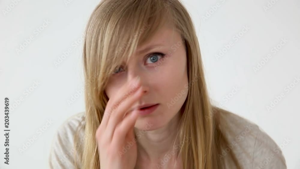beautiful long-haired girl of European appearance with blond hair looks at her face closeup beautiful long-haired girl of European appearance with blond hair looks at her face closeup