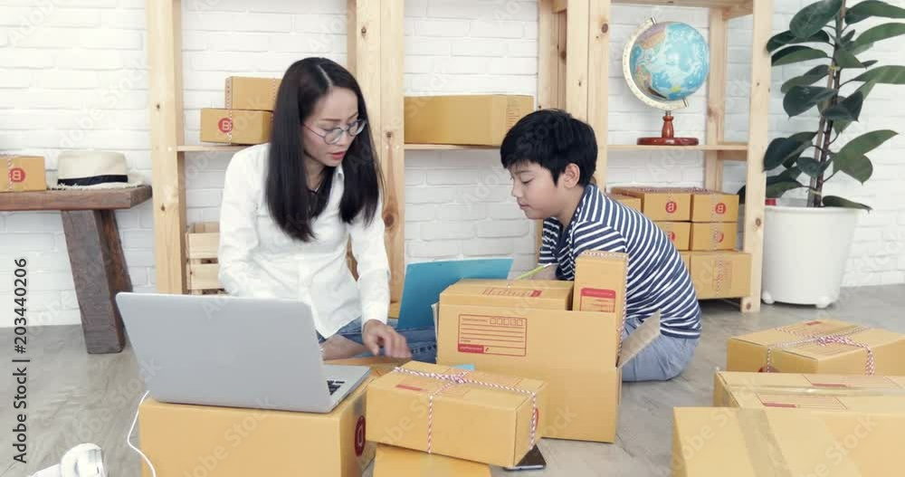 Young asian woman with child boy working and packing Thailand post box to send ,Young business start up. SME, Delivery Project, Young asian woman with child boy working and packing Thailand post box to send ,Young business start up. SME, Delivery Project,