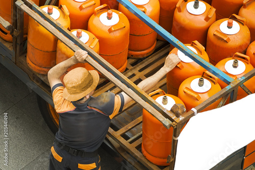 delivery worker with gas butane bottles lgp gpl photo