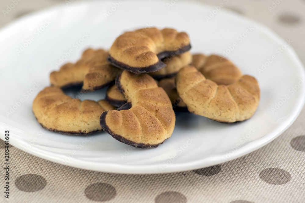 Biscuits rolls on white plate, tasty chocolate sweets for tea break