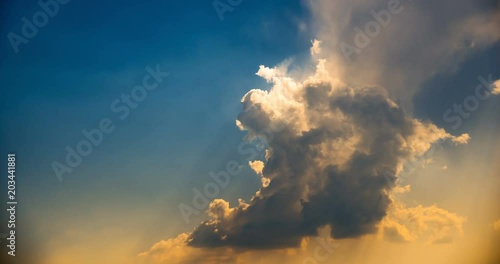 White clouds on a blue sky and in the evening with golden sunrays 4K time lapse footage. photo