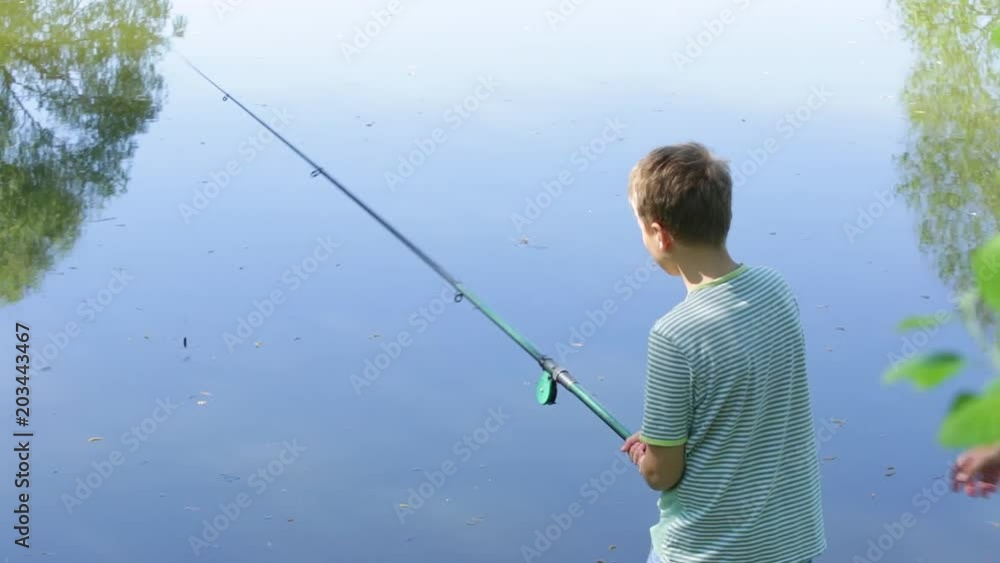 Father teaching young son to fish on river in scenic place. Happy family on summer vacation in countryside concept. Real time full hd video footage. Father teaching young son to fish on river in scenic place. Happy family on summer vacation in countryside concept. Real time full hd video footage.