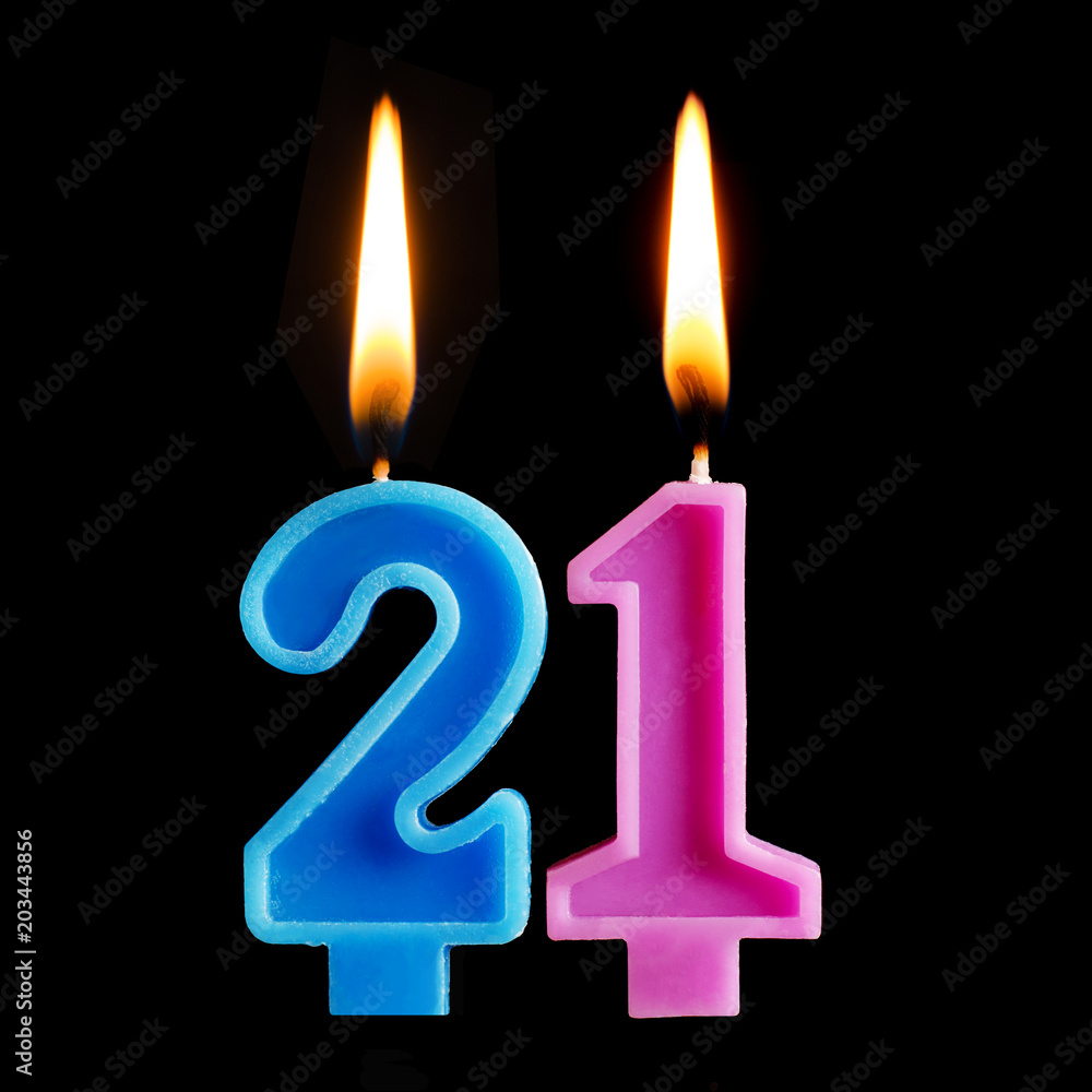 Burning birthday candles in the form of 21 twenty one for cake isolated on black background. The concept of celebrating a birthday, anniversary, important date, holiday Burning birthday candles in the form of 21 twenty one for cake isolated on black background. The concept of celebrating a birthday, anniversary, important date, holiday
