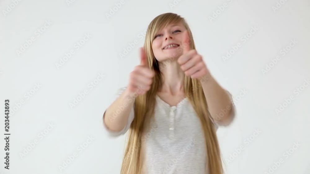 beautiful long-haired girl of European appearance with blond hair showing thumbs up over white abackground