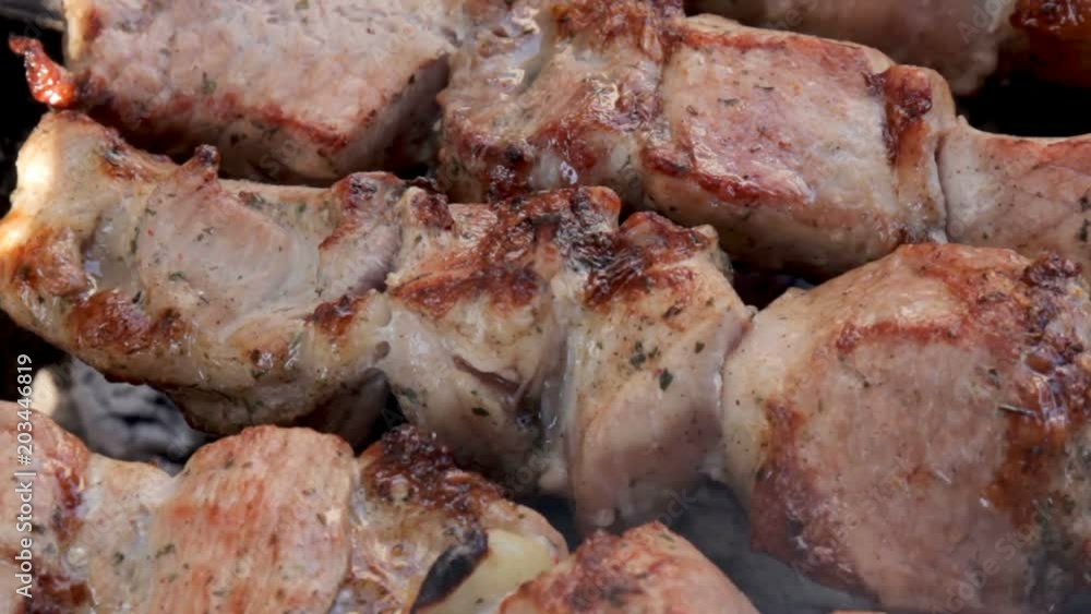The smoke over marinate shashlik preparing on a barbecue. Roast beef kebabs on BBQ grill. Appetizing shish kebab on skewers. The smoke over marinate shashlik preparing on a barbecue. Roast beef kebabs on BBQ grill. Appetizing shish kebab on skewers.