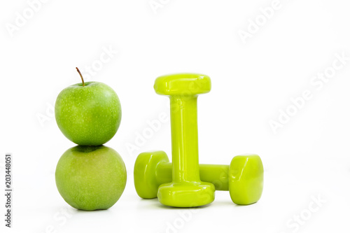 two green apples and dumbbells on white background