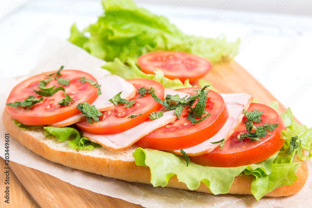 baguette sandwich with ham, tomatoes and lettuce