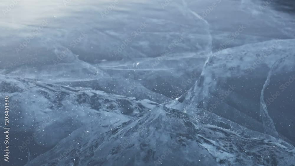 Man in the mittens smashes the ice on the ice. Slow motion. The camera moves behind the ice. A piece of ice is very beautifully broken about the icy with magical cracks. In the frame, a lot of Man in the mittens smashes the ice on the ice. Slow motion. The camera moves behind the ice. A piece of ice is very beautifully broken about the icy with magical cracks. In the frame, a lot of