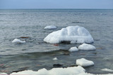 The sea is frozen. Pier in the ice. Sea coast in the ice in the winter. The frozen Baltic Sea.