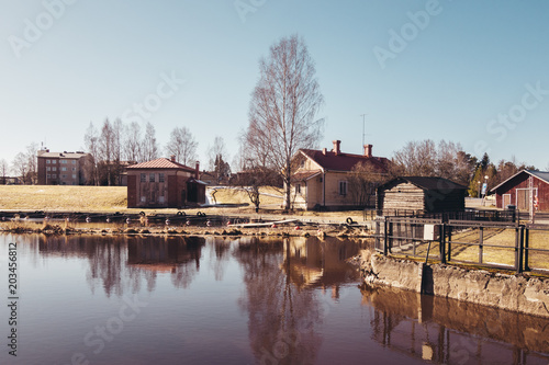 Finland Forssa, Loimijoki river at Kuhalankoski, a small boats marina at summer and with a dam on it's side. On a spring day when all snow has almost melted photo