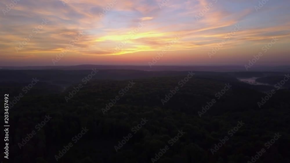 view of a scenic sunset over the forest hills, with toned dramatic colors. Aerial 4K view of a scenic sunset over the forest hills, with toned dramatic colors. Aerial 4K