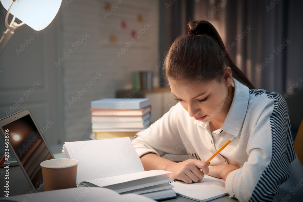 Student doing homework indoors late at night Student doing homework indoors late at night