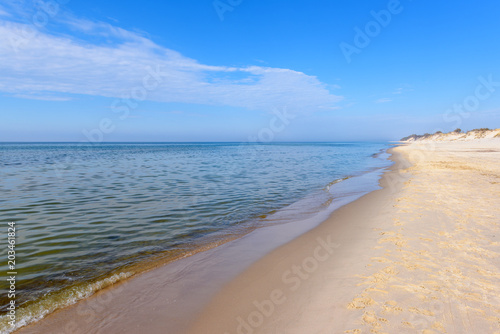 Sea waves and sandy beach in sunny day. Baltic Sea, Poland