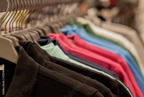 Colorful t-shirts on hangers. Men's stylish clothes. Showcase, sale, shopping. Fashion and trade concept