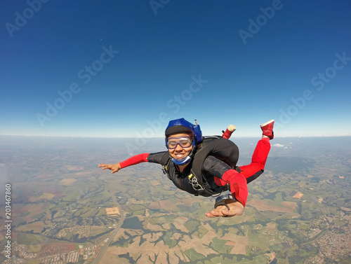 Schilderij op canvas Smiling black woman jumping from parachute