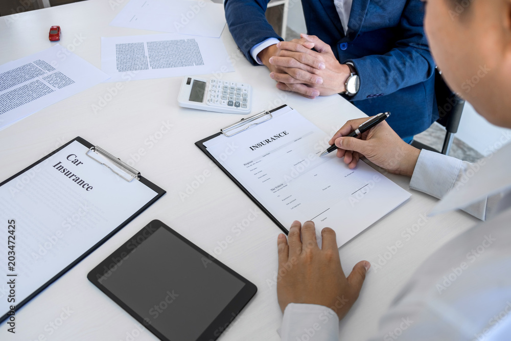 Businessman will be signing a car insurance policy, Agent man is holding the document and waiting for his reply to finish Businessman will be signing a car insurance policy, Agent man is holding the document and waiting for his reply to finish