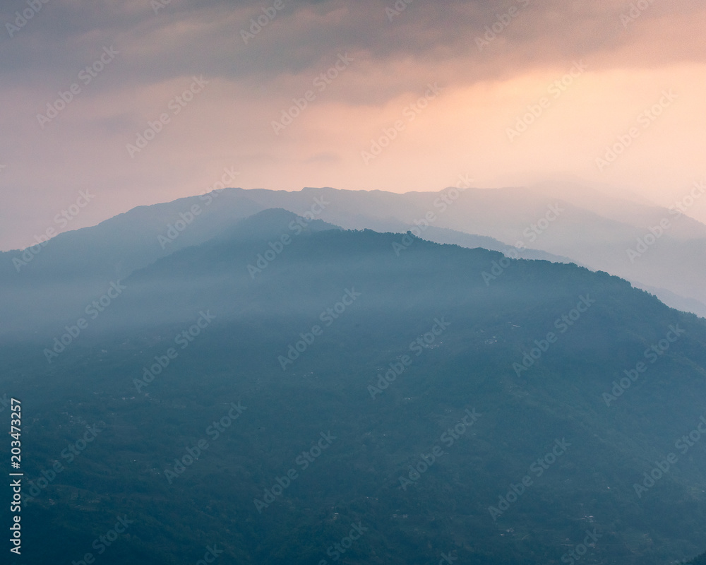 A  view of Misty mountain ranges at the time of Sunrise.
