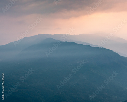 A view of Misty mountain ranges at the time of Sunrise.