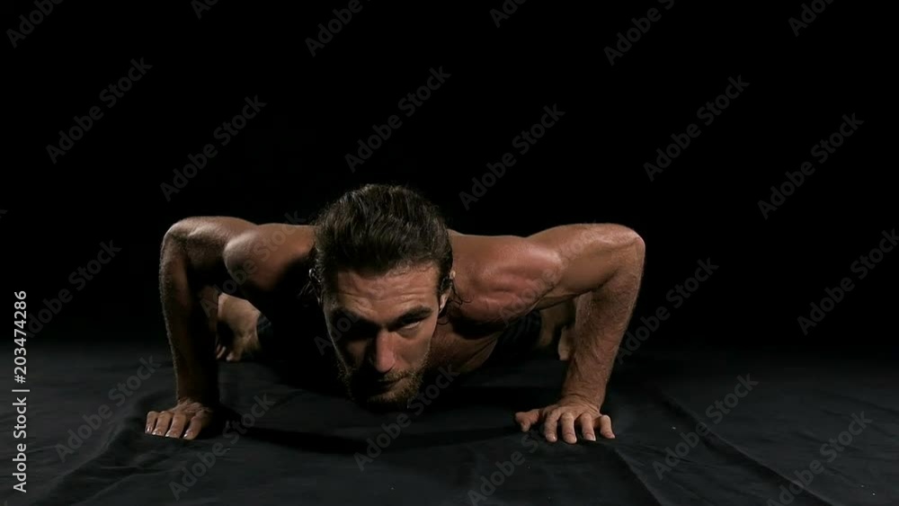 Man doing push up with black background. Half naked man, slow motion. Man doing push up with black background. Half naked man, slow motion.