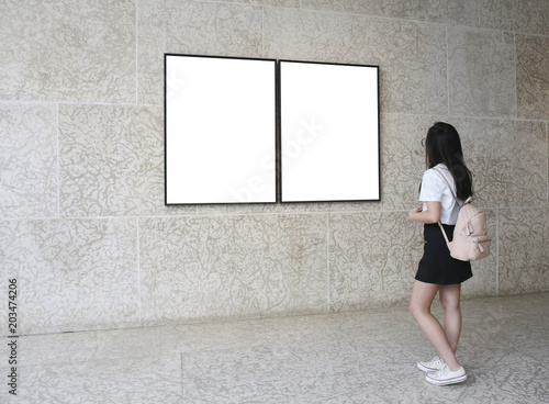 Woman in a gallery looking at empty frames