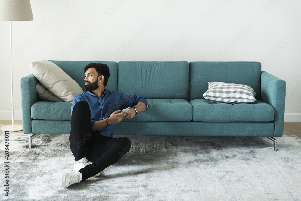 Man using mobile phone on the floor alone Man using mobile phone on the floor alone