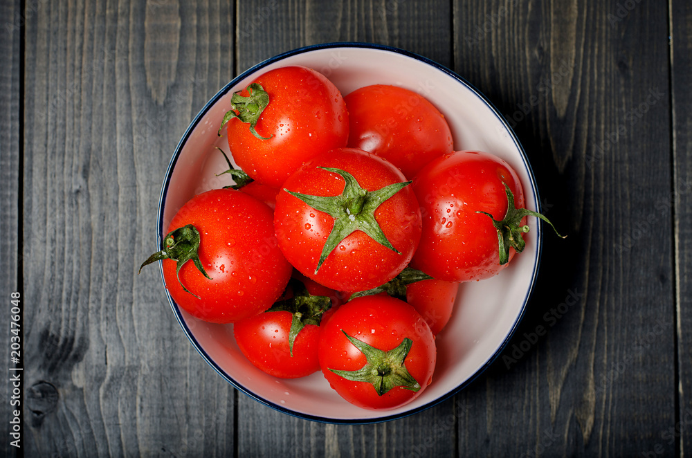 Tomatoes on dark rustic background.