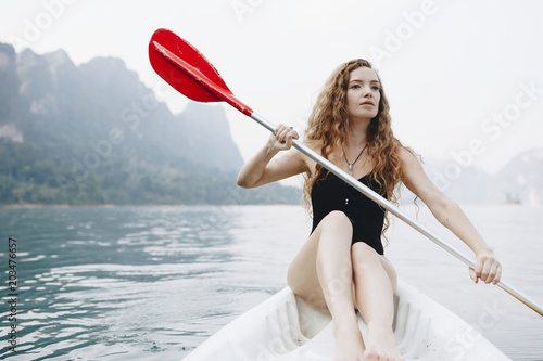 Woman paddling a canoe through a national park © Rawpixel.com