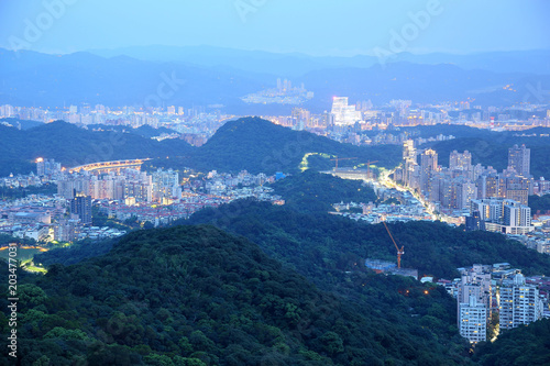 Aerial panorama of Taipei City in a blue gloomy night, with view of NanGang commercical Dist., XinYi Dist., Keelung River and downtown area in evening twilight