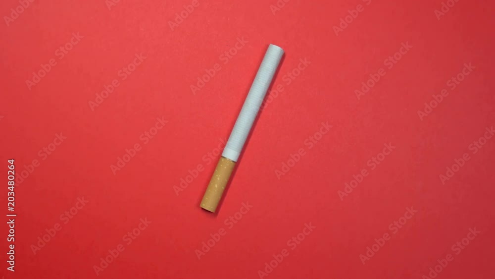 Cigarette close-up, macro shot, slowly spinning on a rotating red background. Cigarette close-up, macro shot, slowly spinning on a rotating red background.