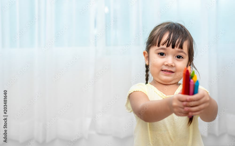 Cute little girl put crayon colors in classroom. Back to school and Education concept. Artist and painting class theme. Cute little girl put crayon colors in classroom. Back to school and Education concept. Artist and painting class theme.
