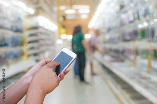 blurred photo smartphone on supermarket store on background with bokeh.