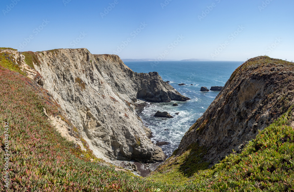 Rocky cliffs and ocean at Bodega Head Trail, Bodega Bay, California, United States on sunny summer day