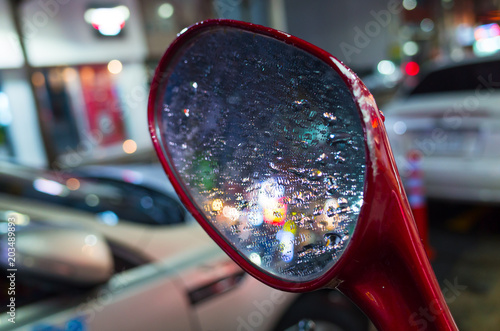 Raindrops on wet scooter mirror