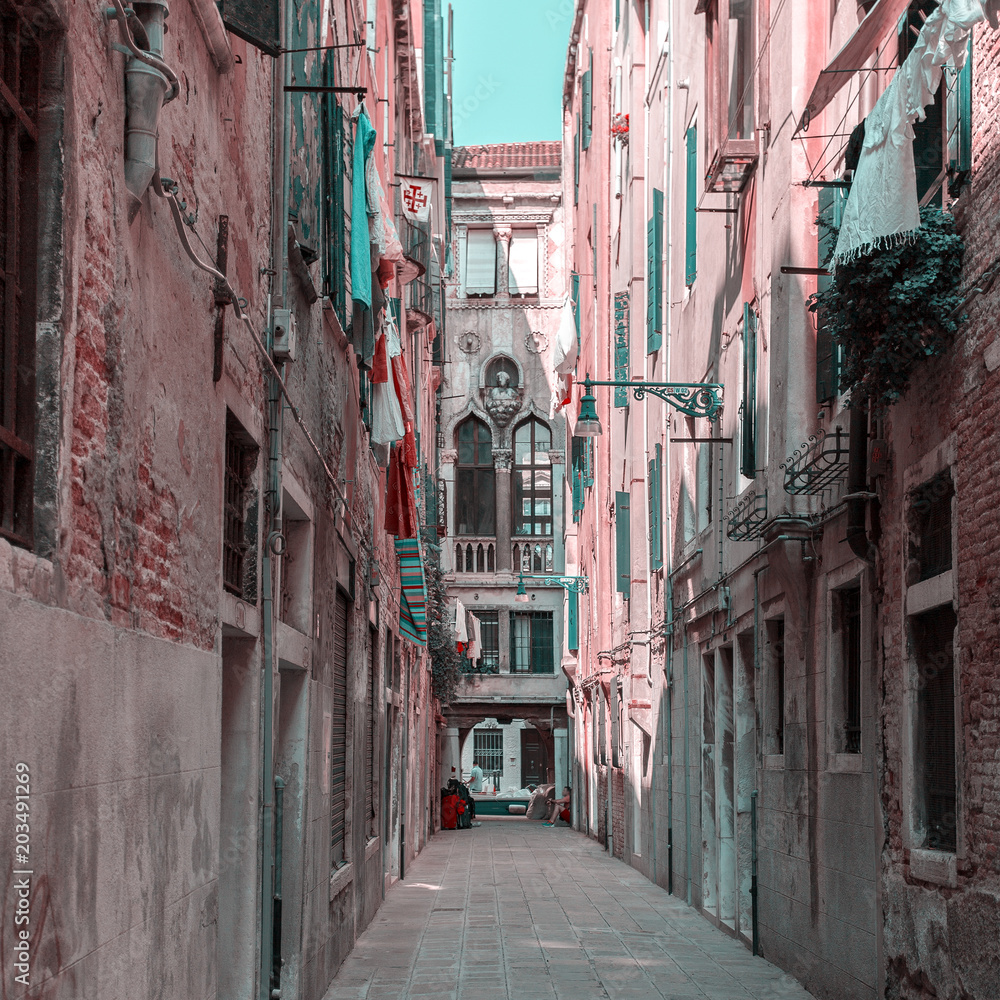 Fototapeta premium One of the many streets of Venice with many cafes, shops, tourists, Italy. Venice is a popular tourist destination of Europe.