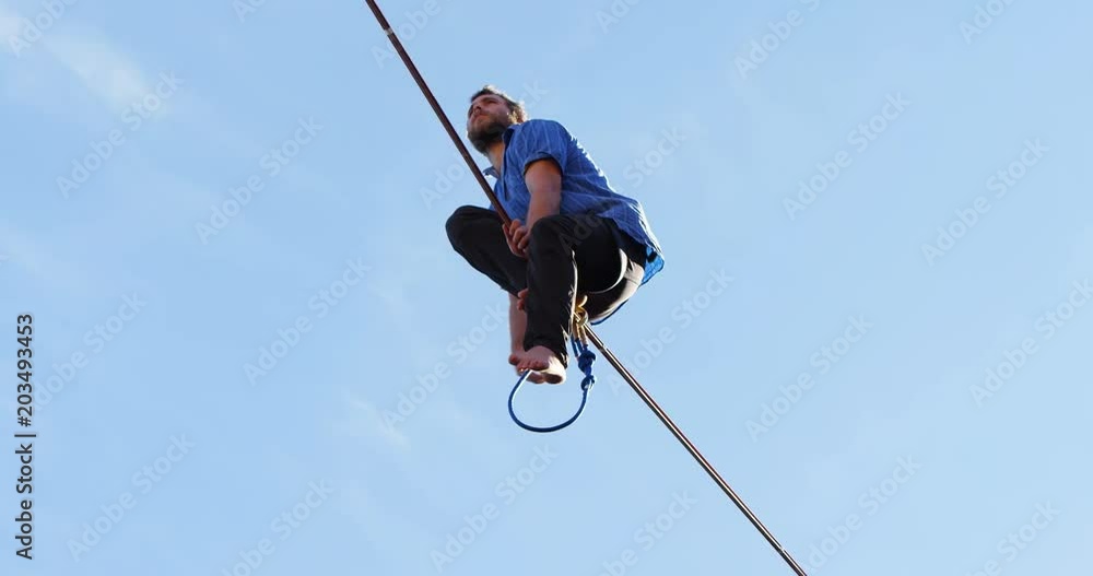 Highline athlete balancing on slack line tight rope Highline athlete balancing on slack line tight rope