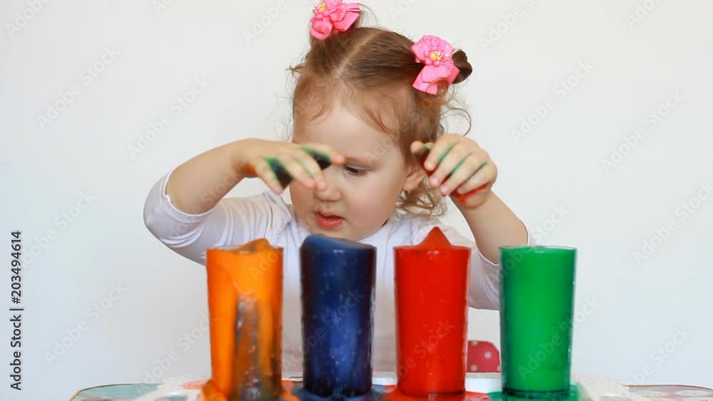 Child and science experiment. Entertainment for children. preschool education. Multicolored drinks. A cute little girl and dirty her hands.